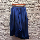 COMME DES GARÇONS
BLUE POLY OVERSIZE DROP SHORTS